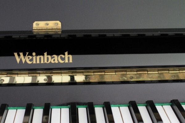 The keys on a black Weinbach piano.